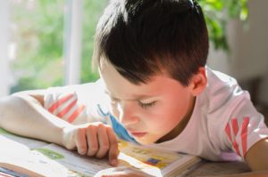 Junge liest ein Buch / fotolia © S.Kobold